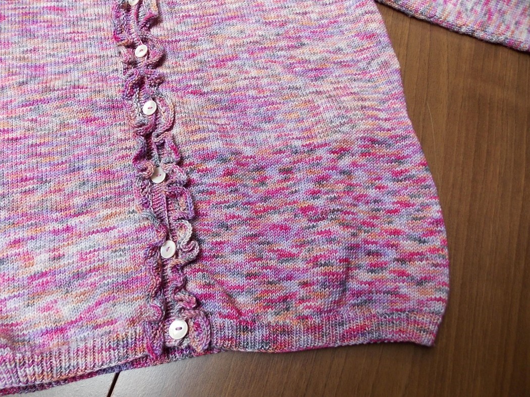 Hands knitting with two balls of similar-color yarn attached to the same project, demonstrating how alternating skeins feeds into an even-looking fabric